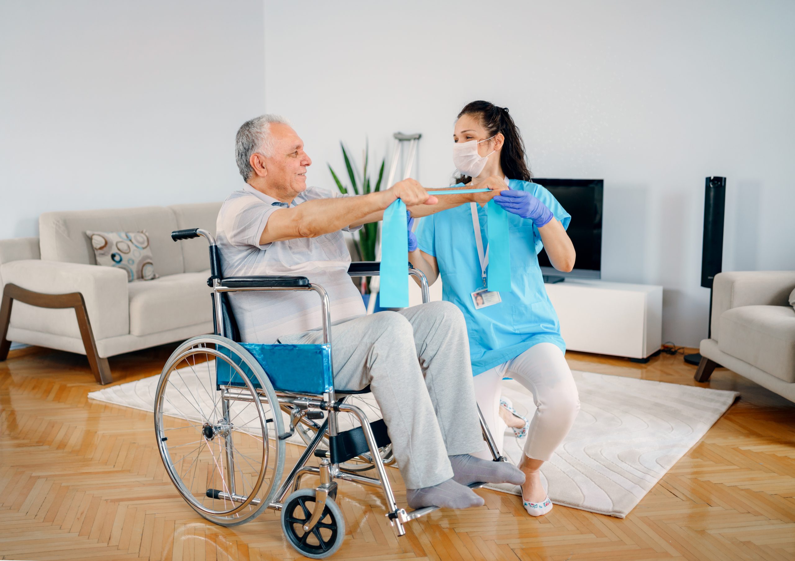 Senior adult man at home with healthcare nurse, physical therapist