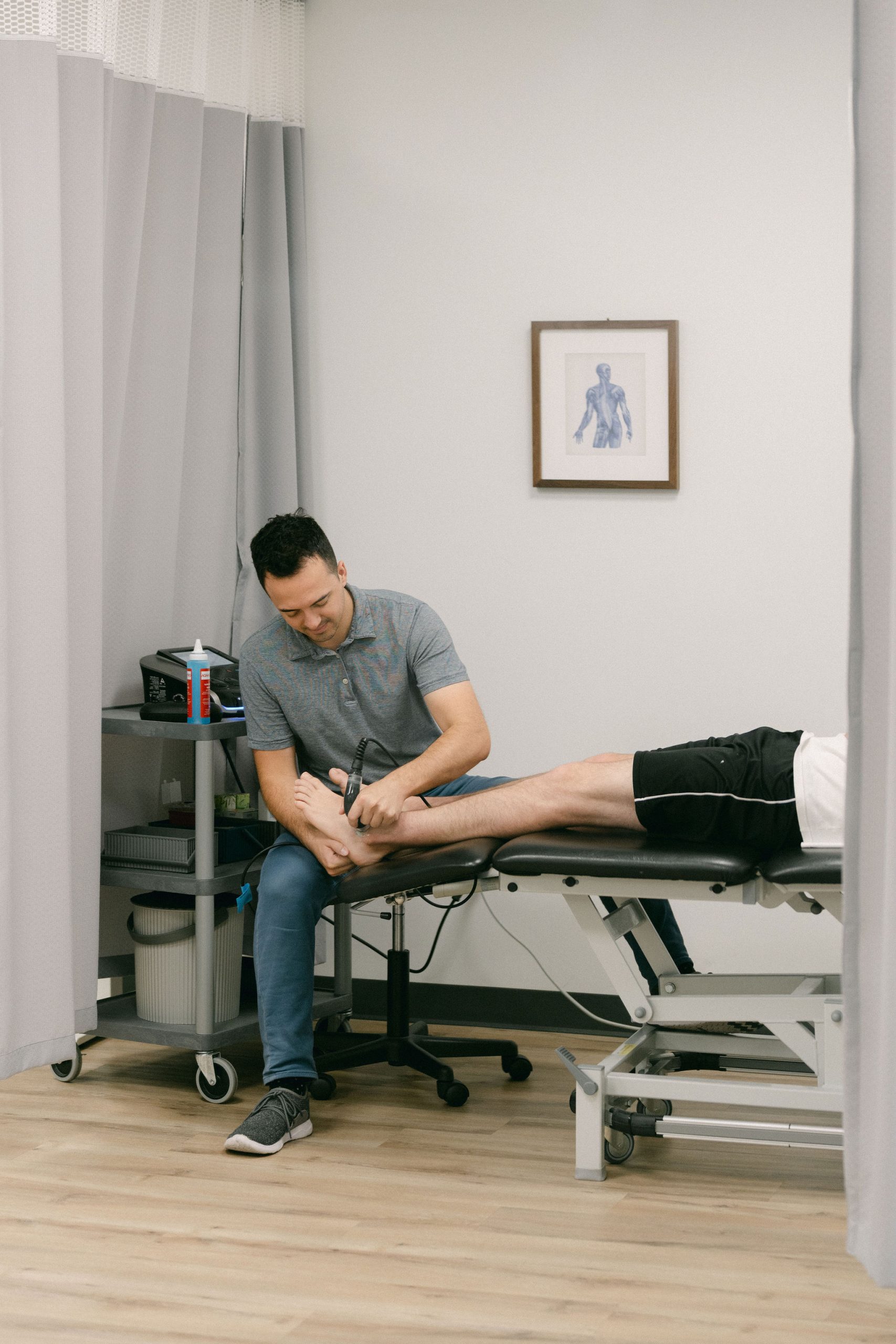 A physiotherapy room with table at work Physiotherapist doing ultrasound therapy at First Line Physiotherapy